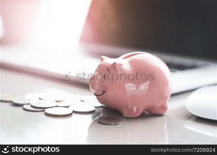 piggy bank with money coins on white table.saving money wealth and financial concept