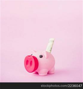 piggy bank with money pink background