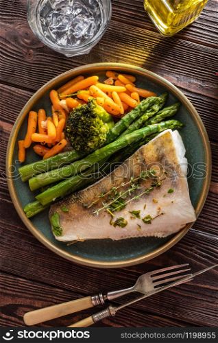 Pike perch fillet with asparagus, broccoli and carrots. Fried fish with stewed greens.