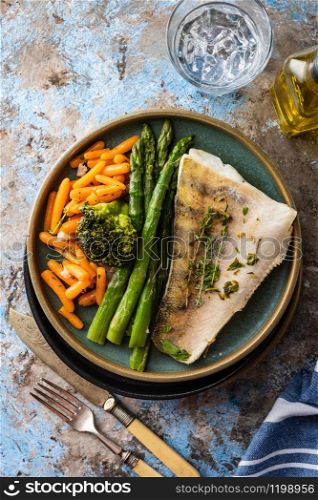 Pike perch fillet with asparagus, broccoli and carrots. Fried fish with stewed greens.