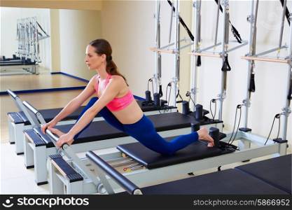 Pilates reformer woman front split exercise workout at gym indoor