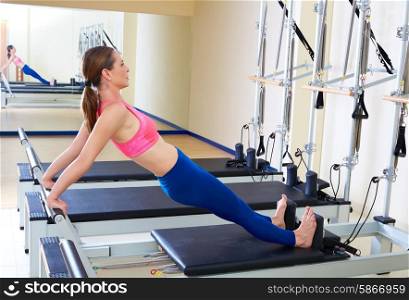 Pilates reformer woman long back stretch exercise workout at gym indoor