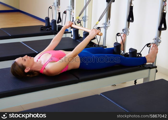 Pilates reformer woman roll up exercise workout at gym indoor