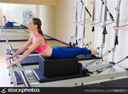 Pilates reformer woman short box swan exercise workout at gym indoor