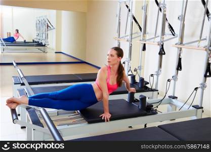 Pilates reformer woman snake twist exercise workout at gym indoor