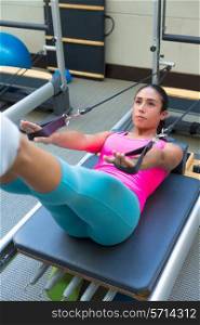 Pilates reformer workout exercises woman brunette at gym indoor