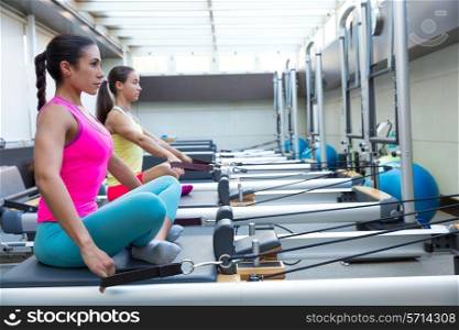 Pilates reformer workout exercises women at gym indoor