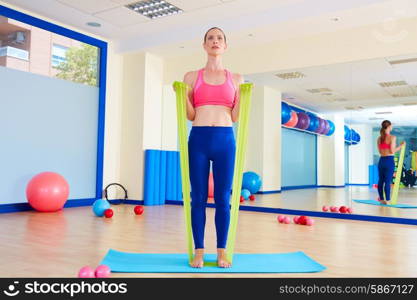 Pilates woman biceps rubber band exercise workout at gym indoor