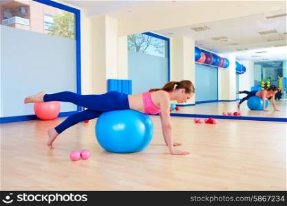 Pilates woman fitball leg pull front exercise workout at gym indoor