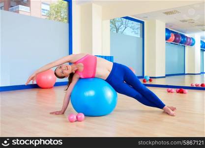 Pilates woman fitball side bend exercise workout at gym indoor
