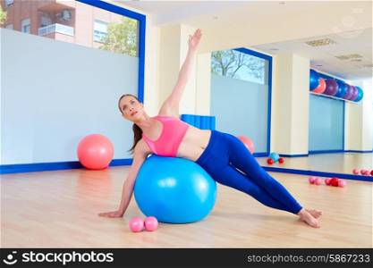 Pilates woman fitball side bend exercise workout at gym indoor