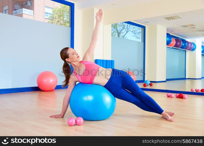 Pilates woman fitball side bend exercise workout at gym indoor