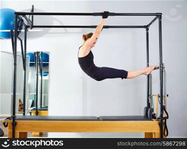 Pilates woman in cadillac acrobatic reformer exercise at gym