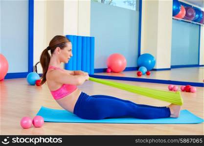Pilates woman rowing rubber band exercise workout at gym indoor