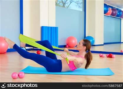 Pilates woman single leg stretch rubber band exercise workout at gym indoor