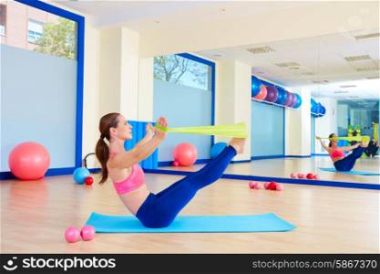 Pilates woman teaser rubber band exercise workout at gym indoor