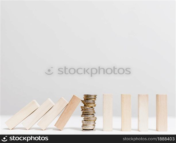pile coins stopping fallen wooden pieces front view . Resolution and high quality beautiful photo. pile coins stopping fallen wooden pieces front view . High quality and resolution beautiful photo concept