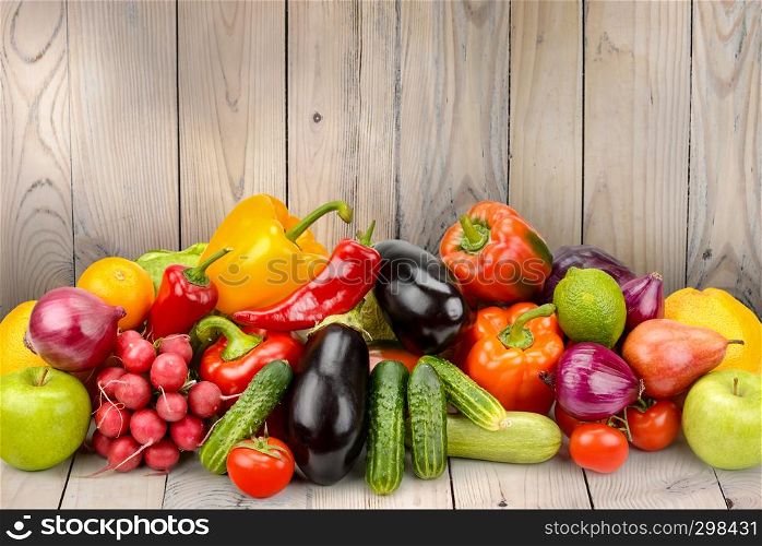 Pile fruits and vegetables on wooden table on background wooden wall. Copy space
