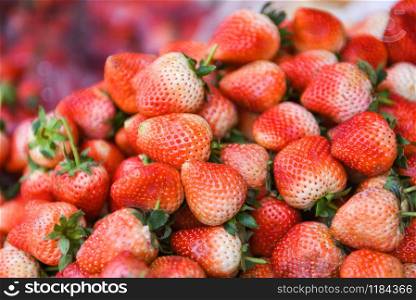Pile od ripe strawberry for sale in the market fruit / harvested fresh strawberries background