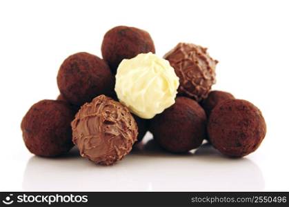 Pile of assorted chocolate truffles isolated on white background