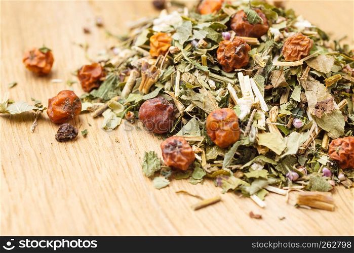 Pile of assorted natural medical dried herb leaves and fruits on wooden surface. Herbaceous plant.. Pile of dry herb leaves and fruits