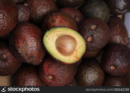Pile of avocados on display at a market stall