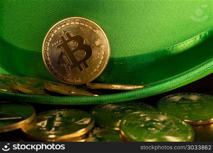 Pile of bitcoins inside green hat St Patricks Day. Treasure of golden bitcoins inside a green velvet hat on wooden table to celebrate luck on St Patrick&rsquo;s Day of March 17th. Pile of bitcoins inside green hat St Patricks Day