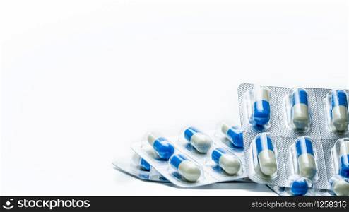 Pile of blue, white capsule pills in blister pack isolated on white background with copy space. Global healthcare concept