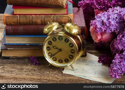 pile of books with clock. pile of books with alarm clock and flowers