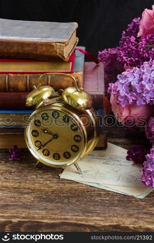pile of books with clock. pile of books with clock and flowers