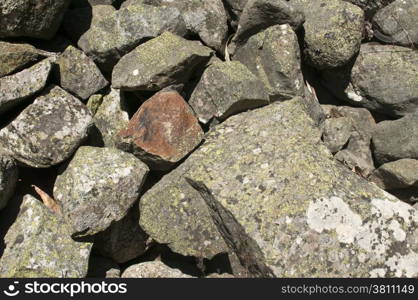 Pile of broken chunks of grey mountain stone closeup as background