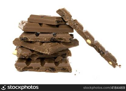 pile of brown chocolate bars with dried fruits isolated on white background