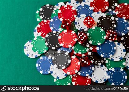 Pile of Casino pocker gambling chips and dices on green table.. Pile of Casino pocker gambling chips and dices on green table