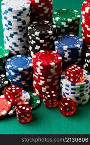 Pile of Casino pocker gambling chips and dices on green table.. Pile of Casino pocker gambling chips and dices on green table