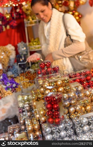 Pile of Christmas balls in plastic boxes woman shopping