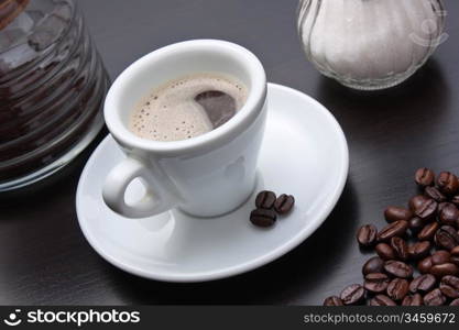 pile of coffee beans and a cup on a gray table