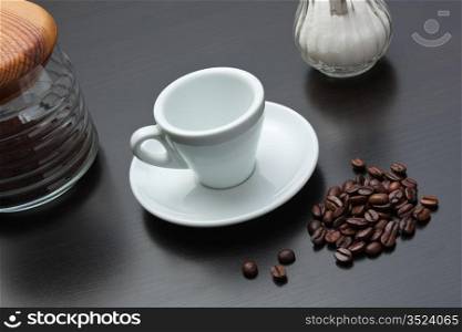pile of coffee beans and a cup on a gray table