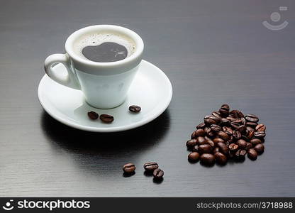 pile of coffee beans and a cup on a gray table