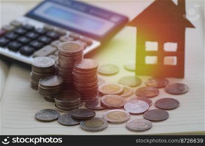 pile of coin with calculator and  house, concept in selling, buying, loan and finance business