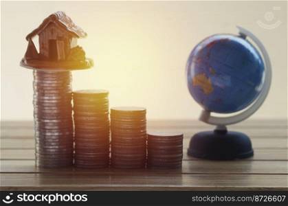 pile of coins,globe and home, concept in house finance on wood table