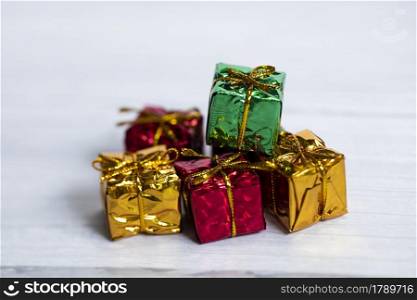 Pile of colored shiny gift boxes with copy space on white wood background,modern retro Christmas design, Colorful presents,Holiday concept space for text. Pile of colored shiny gift boxes with copy space on white wood background,modern retro Christmas design, Colorful presents,Holiday concept