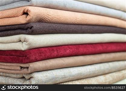 Pile of colorful folded textile. Heap of cloth fabric. Pile of colorful folded textile