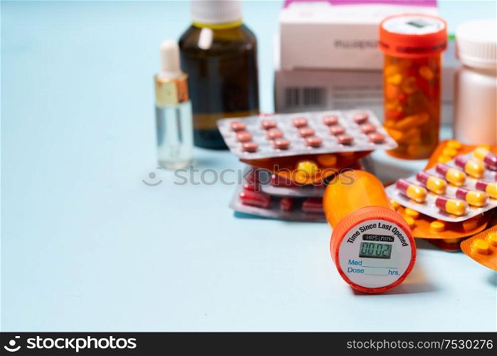Pile of colorful medical pills and bottles on plain blue background with copy space. Drug and antibiotics prescription for treatment medication.. Pile of pills