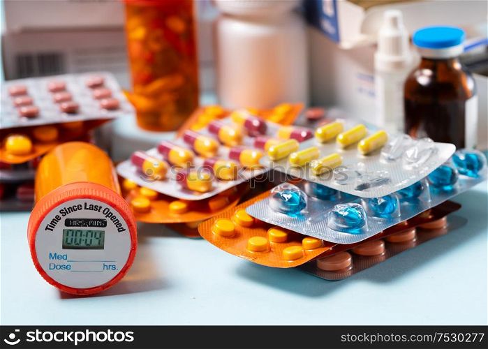 Pile of colorful medical pills in blisters and bottles on blue background. Drug and antibiotics prescription for treatment medication.. Pile of pills