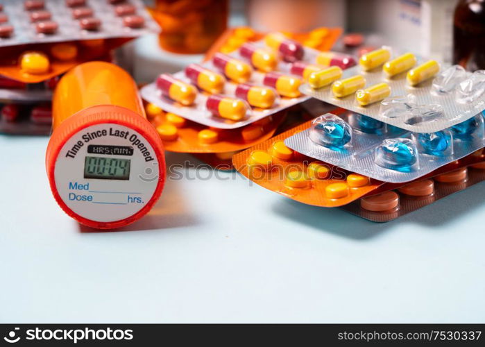 Pile of colorful medical pills in blisters and bottles on blue background. Drug and antibiotics prescription for treatment medication.. Pile of pills