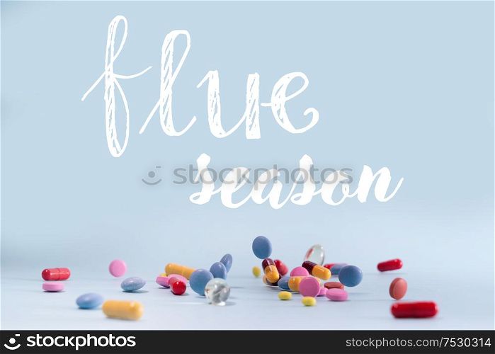 Pile of colorful medical pills on blue background, flue season concept. Pile of pills