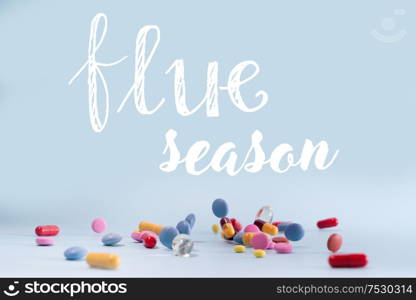 Pile of colorful medical pills on blue background, flue season concept. Pile of pills