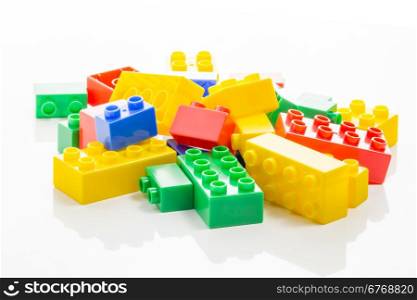 Pile of colorful plastic building bricks on white background