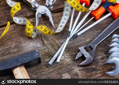 pile of colorful tools with hammer on wooden background. tools kit frame on wooden planks