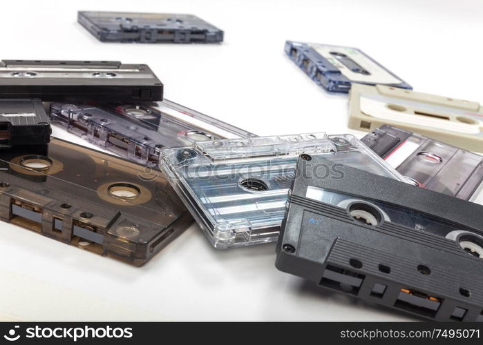 Pile of compact audio cassette tapes on a white background